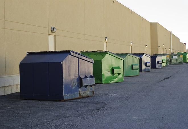 a construction worker disposing of debris into a dumpster in Angleton